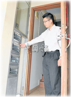 陳明岳指著甲中華大會堂樓下的信箱鋁片,在兩天內兩度失竊。(馬來西亞《中國報》)