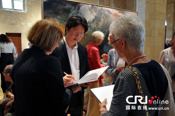 畫家王衍成在個(gè)人畫冊上為法國“粉絲”們簽名