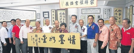 鐘正山(右六起)贈送墨寶予宋群禮夫婦。(馬來西亞《南洋商報》)