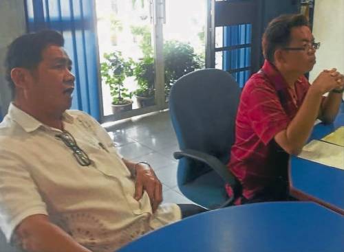 蔡同財(左)陪同林偉良向波德申警方報案。(馬來西亞《南洋商報》)