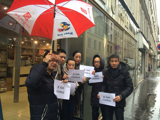 中國僑網(wǎng)法國華人服裝業(yè)總商會(huì)會(huì)長黃小中(右一)與十一區(qū)華商冒雨對(duì)遇難者表示聲援。(法國《歐洲時(shí)報(bào)》/孔帆 攝)