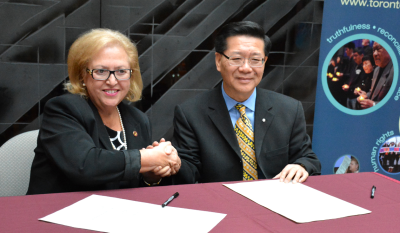 中國(guó)僑網(wǎng)史維會(huì)主席王裕佳(右)與多倫多天主教教育局總監(jiān)高蒂伊正式簽署“合作備忘錄”。(美國(guó)《世界日?qǐng)?bào)》/謝君 攝)