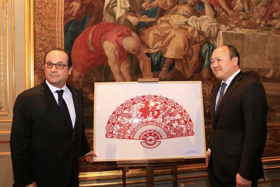 中國僑網(wǎng)陳文雄代表華裔族群向奧朗德總統(tǒng)贈送的富有中國特色的“生肖賀歲”剪紙。(法國《歐洲時報》)
