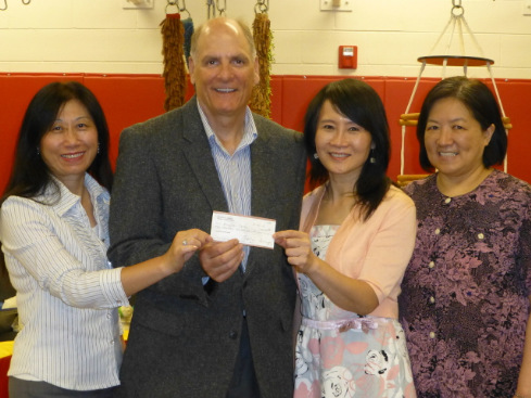 密歇根中華婦女會會長陳淳音（右二）、副會長顏毓萍（左一），代表婦女會捐款盲童中心，由執(zhí)行主任席巴利（左二）代收，右一為財務汪建華。（美國《世界日報》）