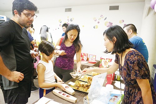 來自不同文化背景的家庭在中秋家庭日限產(chǎn)品嘗月餅。(美國《僑報》/陳辰
