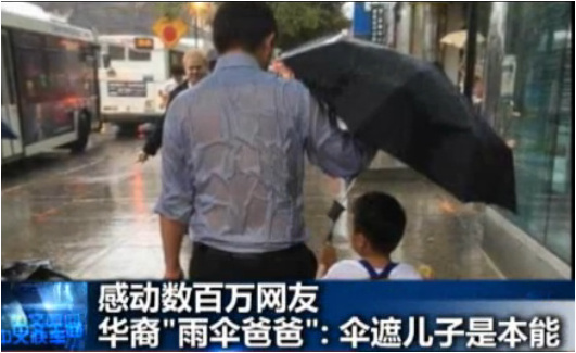 爸爸劉僑為兒子撐傘照片。(美國中文網(wǎng))