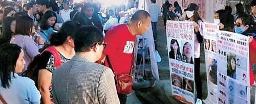 圖為在明洞街頭示威的整容手術(shù)事故受害中國游客(網(wǎng)絡(luò)圖片)