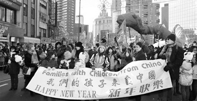 圖為紐約華富新春大游行中領養(yǎng)華童和美國婦女。(陳儒斌攝)