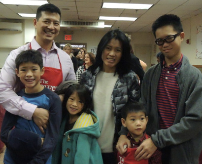 蘇先生帶著全家在包厘救濟站的感恩節(jié)活動上做義工。(美國《世界日報》/高夢梓