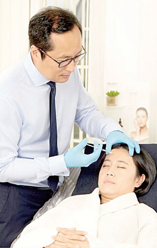 華人整形醫(yī)生Mark-Ho-Asjoe在為客人注射額頭。(圖片來(lái)源:受訪(fǎng)者供圖)