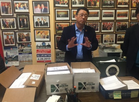 陳善莊正在展示收集的民眾請愿信。(美國《世界日報》/黃伊奕