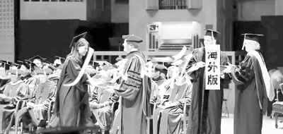 作者在畢業(yè)典禮上領(lǐng)取學位證書。