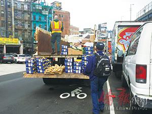 圖為突擊檢查的衛(wèi)生局執(zhí)法人員將沒收商品搬上環(huán)衛(wèi)局垃圾車。