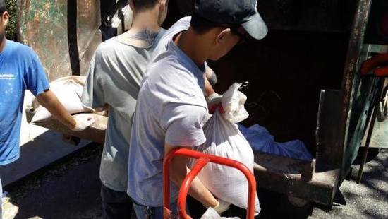 幾名華裔男子快速的將白色袋子搬上卡車(chē)離去。(美國(guó)《世界日?qǐng)?bào)》/黃伊奕