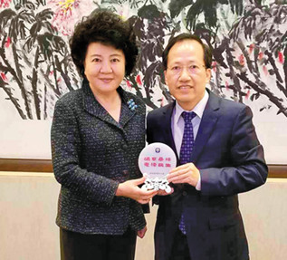 圖為梁冠軍(右)與國務(wù)院僑辦主任裘援平合影。