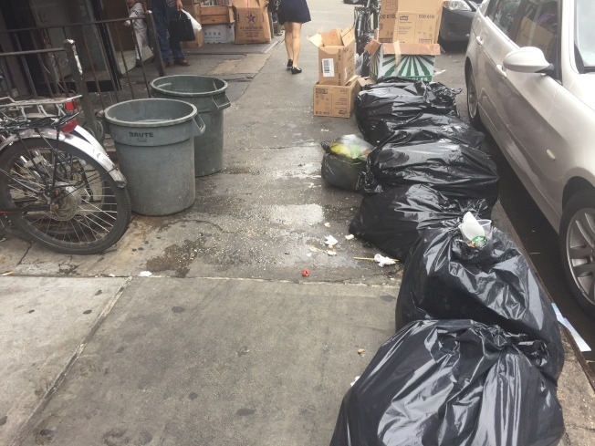 被污水油漬布滿的華埠東百老匯人行道。(美國《世界日報》/尹英姿