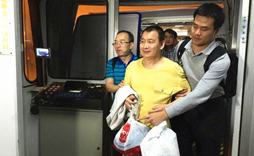 黃某被押解走出機(jī)艙。蔡巖紅攝