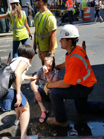 救護人員為一跌倒路邊的老嫗施救。(美國《世界日報》)
