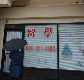 即將面臨遣返的一名女生冒雨到中介門前卻遭閉門羹。(美國《世界日?qǐng)?bào)》/高梓原