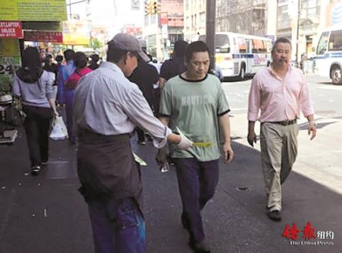 紐約法拉盛街頭常有人發(fā)放華人補(bǔ)習(xí)班廣告。(美國《僑報(bào)》圖片)