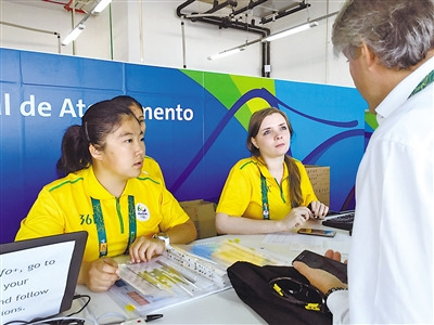 侯嘉怡(左一)在媒體注冊中心為記者提供語言翻譯服務(wù)