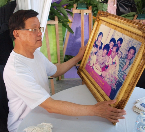 方天興拿著與母親慶生的照片,如今只留下回憶。(馬來西亞《星洲日?qǐng)?bào)》)