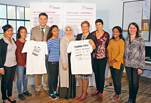 羅鬢妮(右四)與移民中心人員合照。左三為安省省議員董晗鵬。(加拿大《星島日報》)