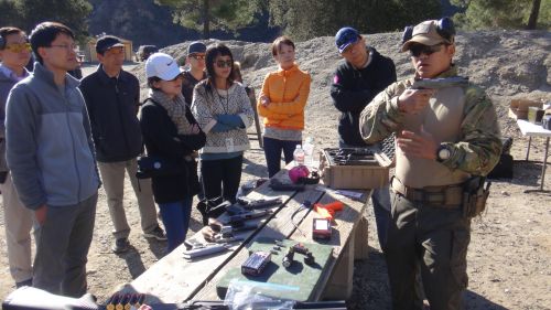 美國亞凱迪亞華人槍友協會李教練(右)在講解手槍的使用和保管知識。(美國《僑報》/高睿