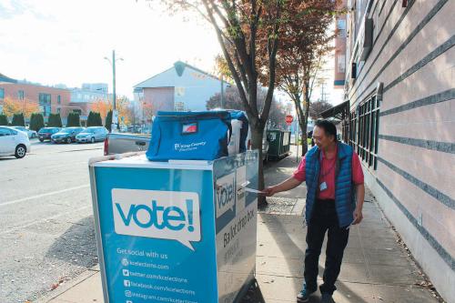 華裔潘先生把選票投入投票箱。(美國(guó)《僑報(bào)》記者