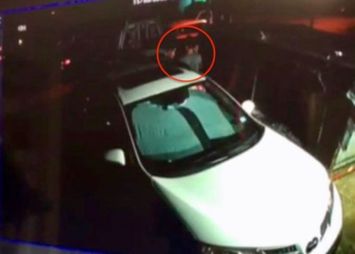 歹徒持槍搶劫,華人曲先生(途中紅圈處)舉手投降。(美國《世界日報》/取自曲先生監(jiān)控錄像)