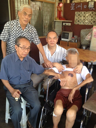 中國僑網(wǎng)何子孟(左坐者)探訪死者父親黎材殿(右坐者);后排左起為盧家援及陳大成。(馬來西亞《星洲日?qǐng)?bào)》)