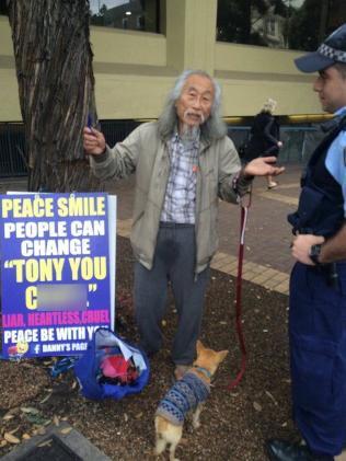 中國僑網(wǎng)林丹尼與其引發(fā)爭議的示威標(biāo)語牌。(澳洲網(wǎng))