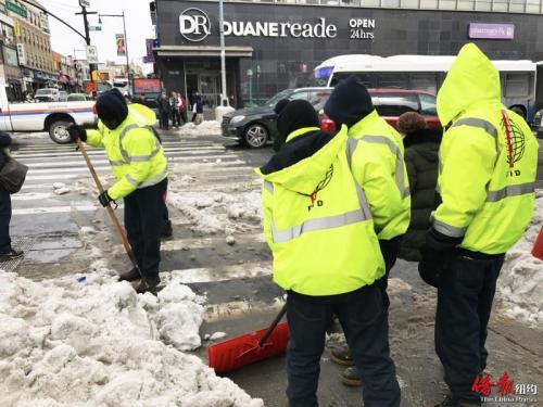 中國(guó)僑網(wǎng)法拉盛商改區(qū)工作人員認(rèn)真鏟雪。(美國(guó)《僑報(bào)》/王伊琳 攝)