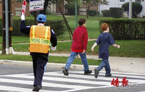 中國僑網(wǎng)校園交通安全員在督導(dǎo)學(xué)生過馬路。(美國《僑報(bào)》資料圖)