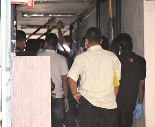 中國僑網警員合力撬開死者住家的大門。(馬來西亞《光華日報》)