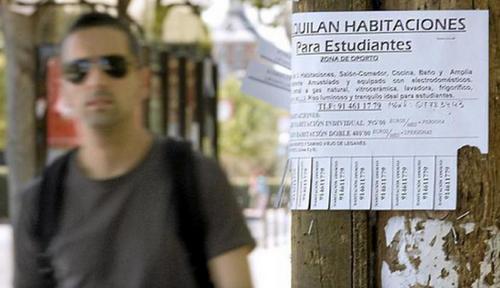 中國僑網(wǎng)圖為一名青年在街邊尋找學(xué)生租房的小廣告。(西班牙《歐浪網(wǎng)》)