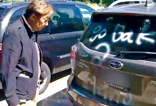 中國僑網(wǎng)高先生檢視遭人破壞的座駕。(加拿大《星島日報》)