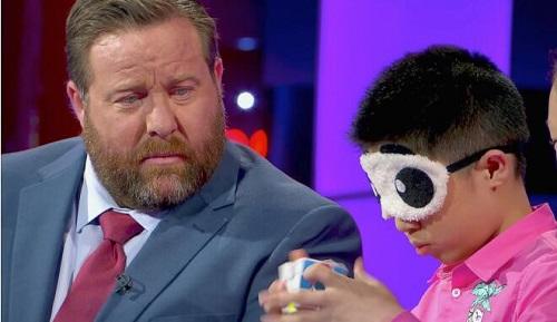 中國僑網(wǎng)資料圖:闕劍宇蒙眼復(fù)原魔方(圖片來源于《南華早報》)