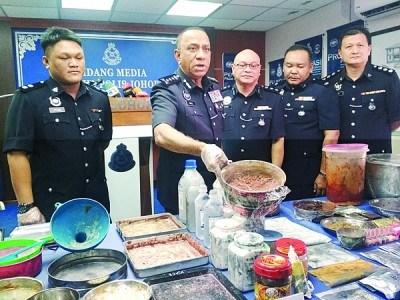 中國(guó)僑網(wǎng)莫哈末卡利(左2)展示行動(dòng)中起獲的毒品粉末。(馬來(lái)西亞《光華日?qǐng)?bào)》)