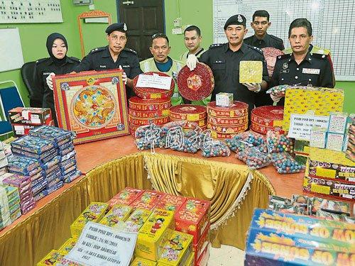 中國(guó)僑網(wǎng)莫哈末阿里(前排右2)展示起獲的煙花和爆竹。(馬來西亞《中國(guó)報(bào)》)