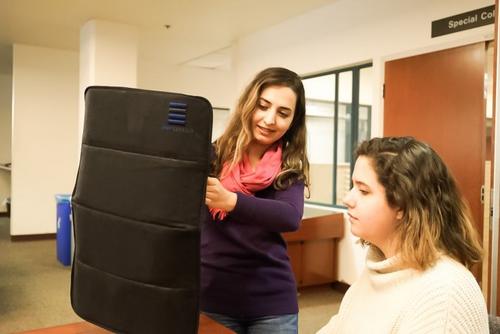 中國僑網(wǎng)學校教師正在嘗試展開便攜防彈盾。(美國《僑報》)