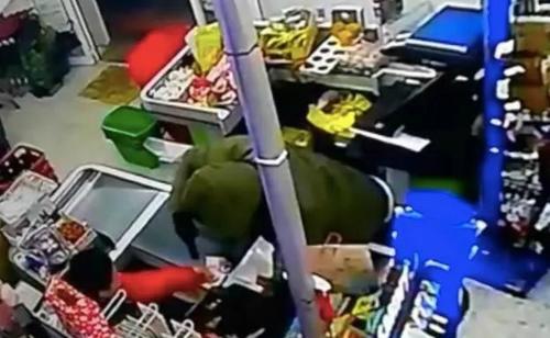 中國(guó)僑網(wǎng)監(jiān)控錄像拍下的持槍劫匪在收銀臺(tái)處。(西班牙《歐華報(bào)》)