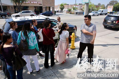 中國僑網(wǎng)幾名按摩執(zhí)照班的畢業(yè)生(左側(cè))在與校方負責叫警察的職員(右側(cè))理論。(美國《世界日報》/邱晨 攝)