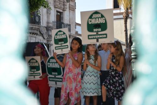 中國僑網(wǎng)林伍特市的孩子們?yōu)榻≥x高舉手牌。(美國《世界日報》/王千惠 攝)