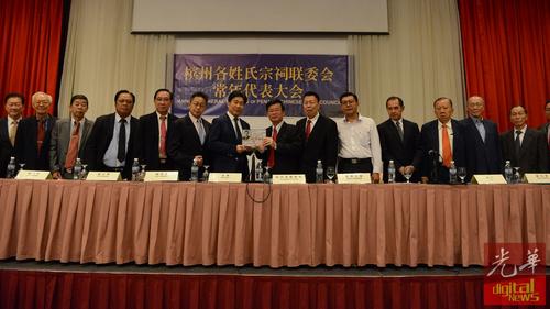 中國(guó)僑網(wǎng)張威如(左7)贈(zèng)送紀(jì)念品予曹觀友(左8)。(馬來(lái)西亞《光華日?qǐng)?bào)》)