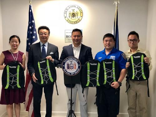 中國僑網(wǎng)金兌錫(中)、109分局和第一保健歡迎小區(qū)學(xué)生到返校送禮活動領(lǐng)取書包等用具。(美國《世界日報》/朱蕾 攝)