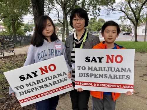 中國僑網(wǎng)美國加州華裔家長張秀靜(中)和她的兩個(gè)孩子一起加入集會。(美國《世界日報(bào)》/朱蕾 攝)