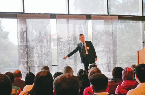 中國(guó)僑網(wǎng)斯坦福大學(xué)歷史學(xué)家張少書(shū)指著老照片中的中國(guó)人身影。(美國(guó)《世界日?qǐng)?bào)》/梁雨辰 攝)