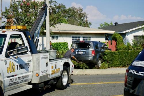 中國僑網(wǎng)工作人員將沖入華人家的車輛拖出。(美國《世界日報》/陳開攝影)