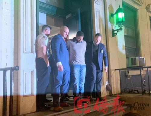 中國(guó)僑網(wǎng)圖為桑托斯(右2)此前被警方押送出警局。 (紐約《僑報(bào)》 楊澄雨/攝)